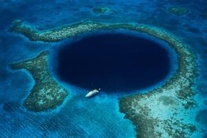 Belize, Lighthouse Reef, boat moored at Blue Hole, aerial view