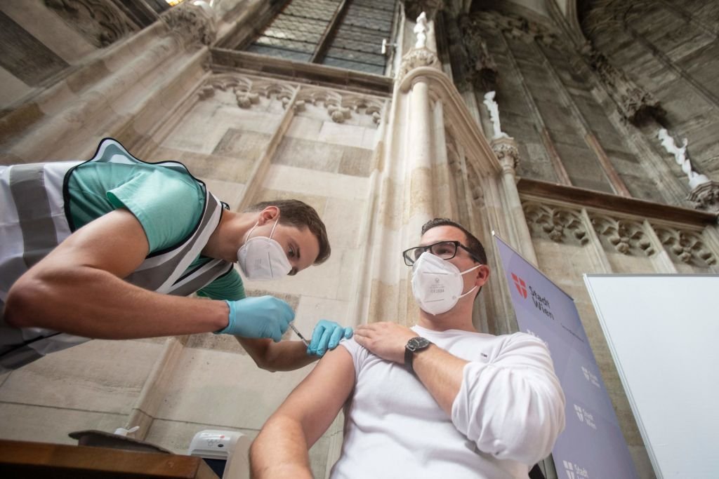Um homem recebe uma vacina no centro de vacinação instalado na Capela Bárbara da famosa Catedral de Santo Estêvão, em Viena, em 11 de agosto de 2021, em meio à nova pandemia de coronavírus