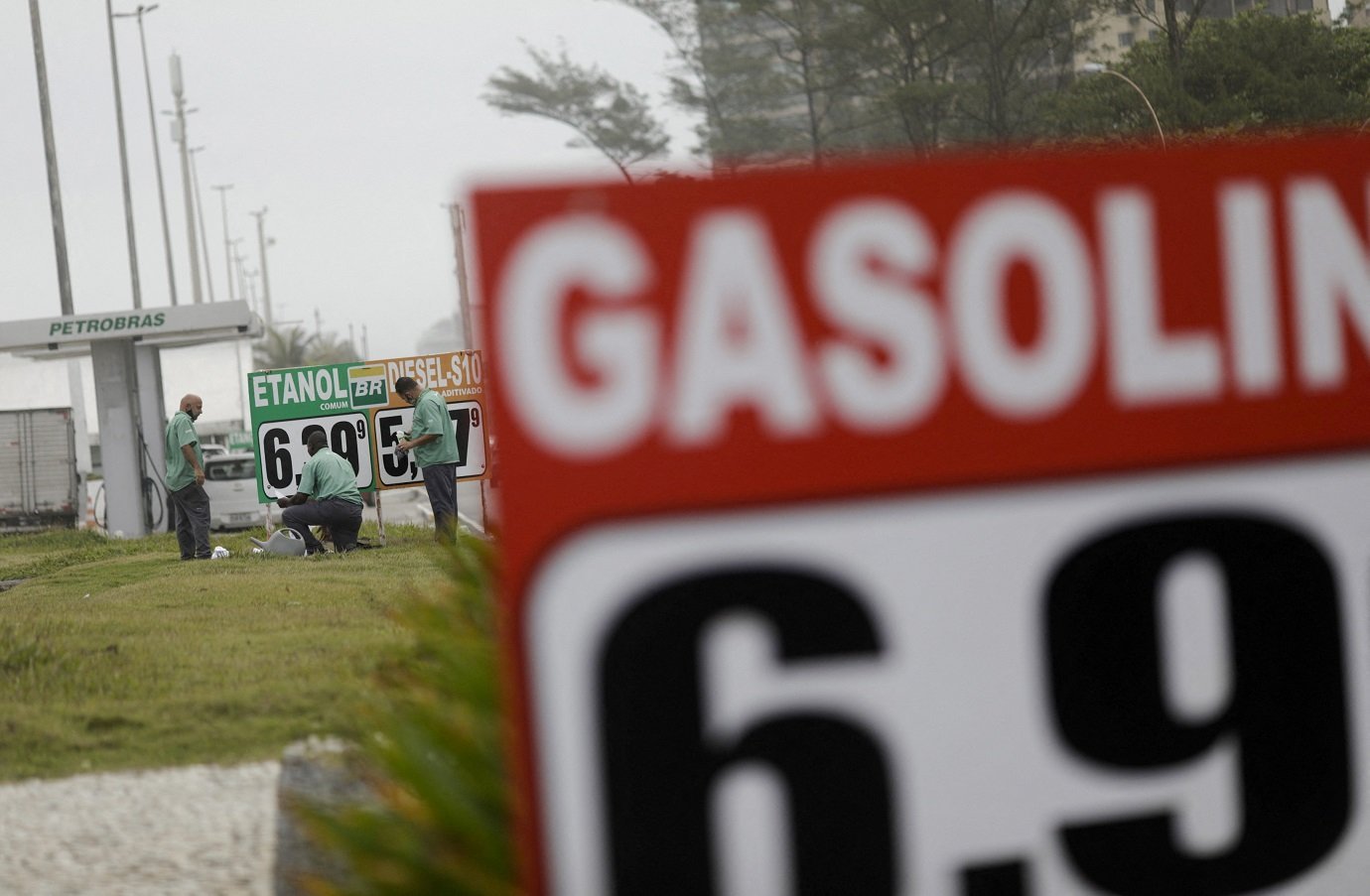 Funcionários atualizam preços dos combustíveis em posto de gasolina