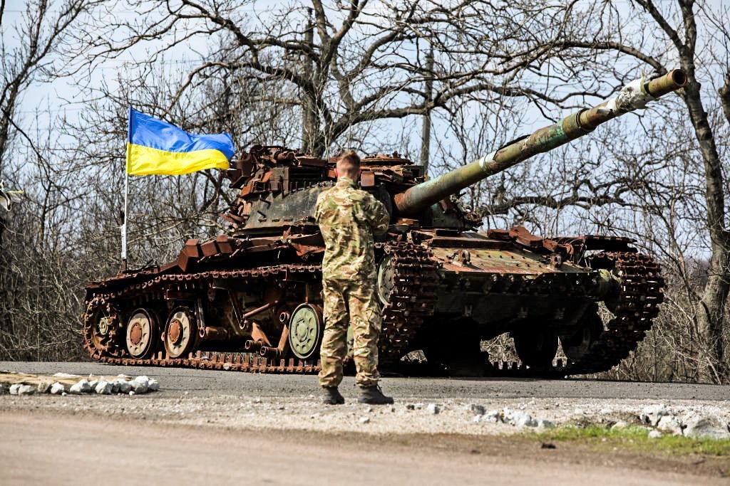 A Ukrainian serviceman stands next to a Ukrainian tank destroyed in 2014 by Russia backed separatists, on the front line near the small town of Pisky, Donetsk region, on April 21, 2021. - Ukraine's President Volodymyr Zelensky on April 20, 2021, invited Russian leader Vladimir Putin to meet in war-torn eastern Ukraine, stressing that millions of lives were at stake from fresh fighting in the separatist conflict. (Photo by Aleksey Filippov / AFP) (Photo by ALEKSEY FILIPPOV/AFP via Getty Images)